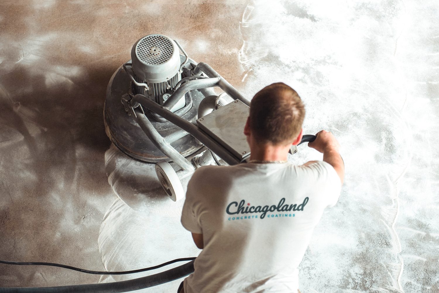 Technician applying epoxy flooring coating inside a Cook County - IL garage to create a sealed surface